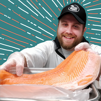 Ethan, HWFC's Meat Department Assistant Manager, Smiling and weighing a large filet of salmon on a solid blue background with illustrated lines 